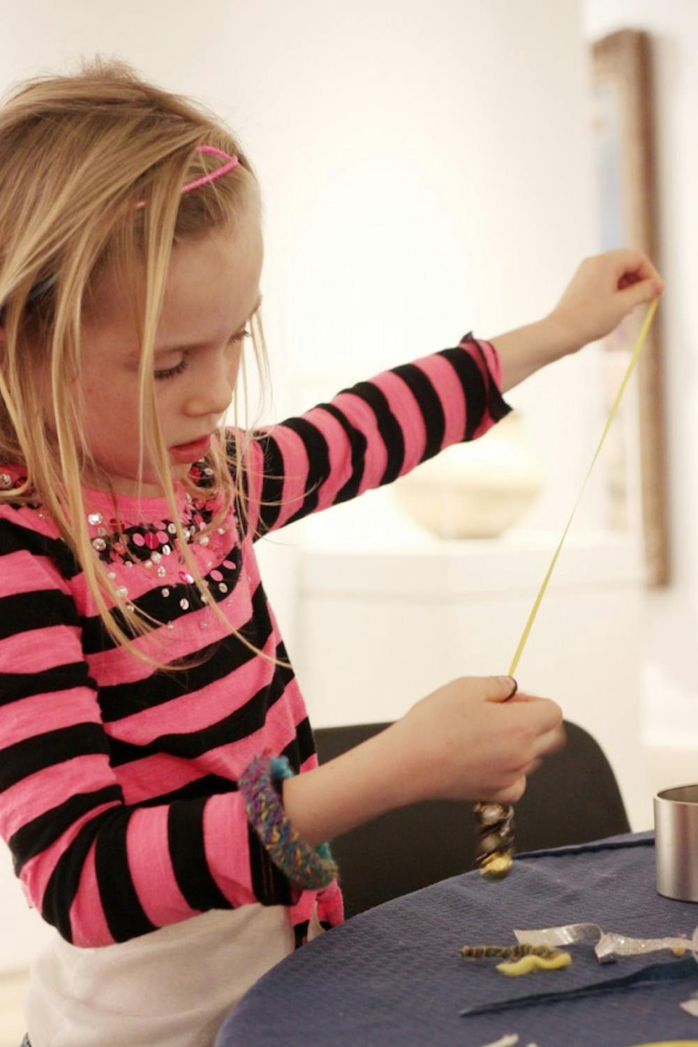 The Ackland Art Museum hosted a Winter Pajama Party on Saturday from 2-5 pm.  Children came in their pajamas and participated in story time, costume dress up, and arts and crafts activities.  Flora Ulrich, 7, makes a bracelet  at the event. 