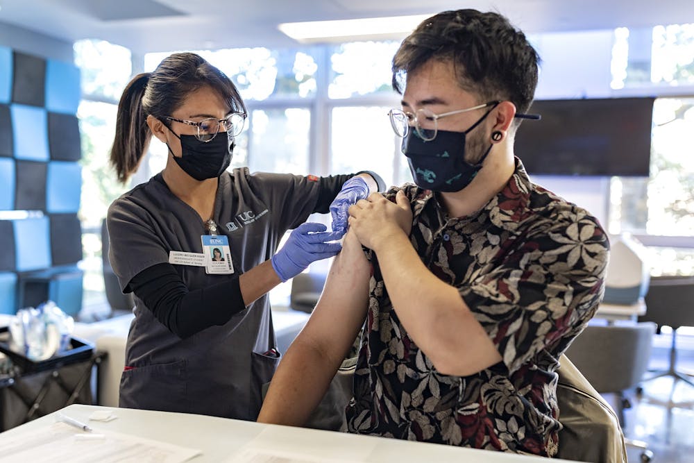 UNC student Levon Lau receives a COVID-19 booster shot at UNC's Carmichael Residence Hall from Lucero Becquer Kiser, a senior in the UNC School of Nursing, on October 26, 2021. Photo courtesy of Johnny Andrews/UNC Media Relations.