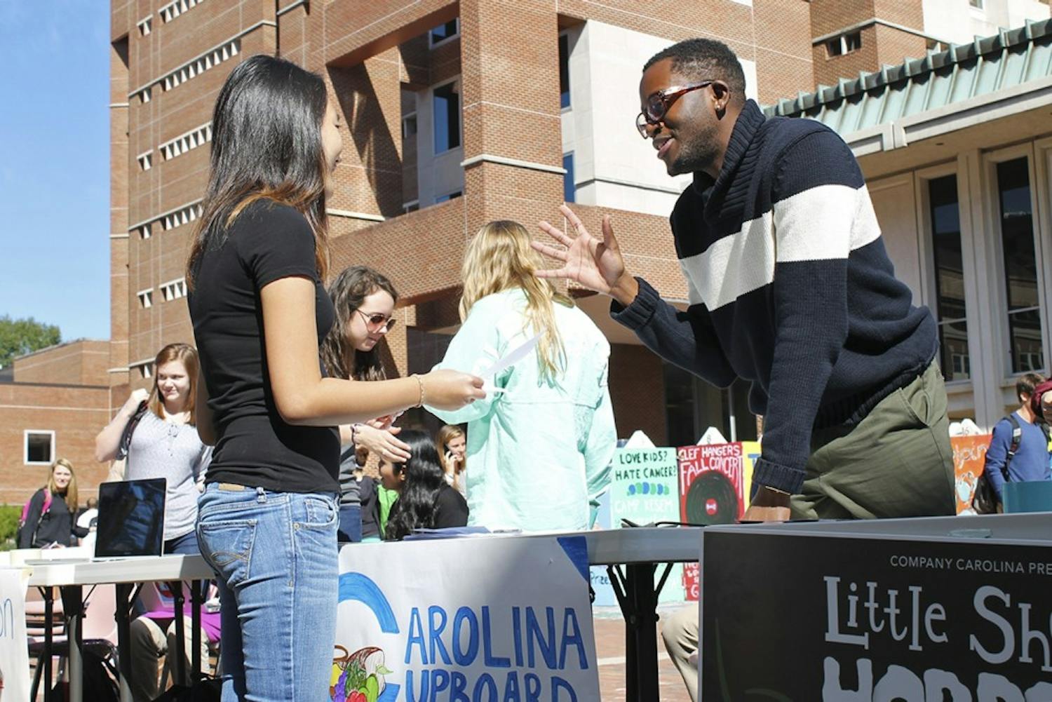 Roderick Gladney (right), founder and chairman of Carolina Cupboard, an organization that provides free food to the UNC campus community, helps recruit new members in the Pit in October 2014. DTH file photo by Johanna Ferebee.