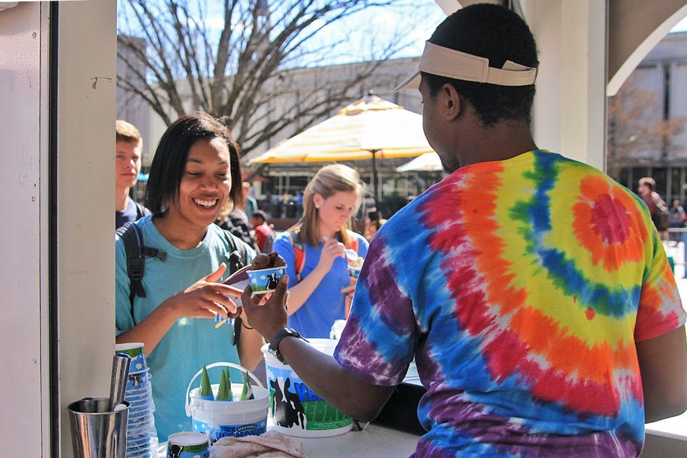 TJ Woodard (right), a junior economics major, serves Ben and Jerry’s ice cream to Kady Forbes, a junior journalism and communications major.