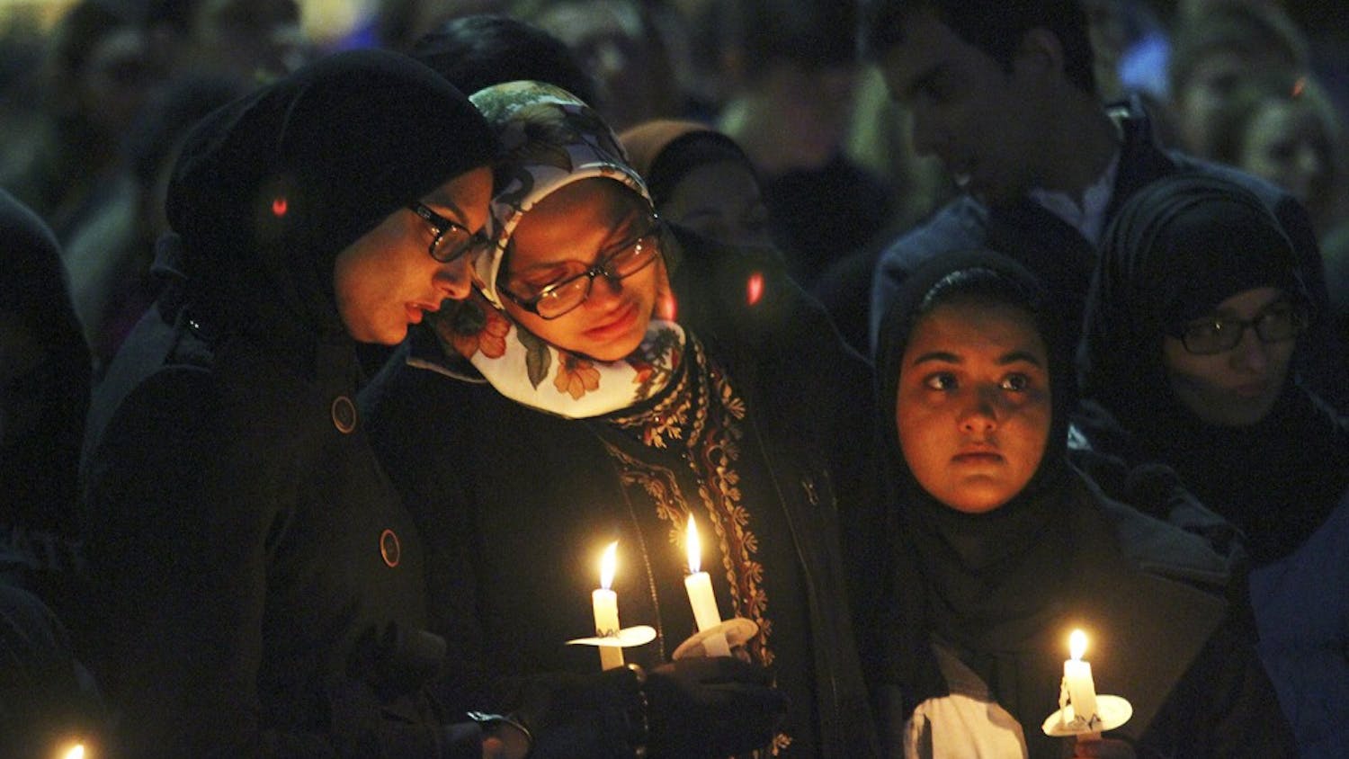 Mourners hold candles at a vigil in the Pit for Deah Shaddy Barakat, Yusor Mohammad Abu-Salha and Razan Mohammad Abu-Salha on Wednesday.