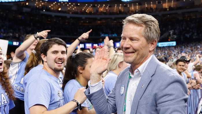 Kevin Guskiewicz, chancellor of UNC-Chapel Hill, celebrates with students after a Carolina victory in the Final Four of the NCAA Tournament against Duke in New Orleans on Saturday, April 2, 2022. UNC won 81-77.