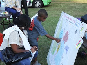 Andreah Williams and her son Tyshawn Pope look for their home on the community display at the Hargrove Community Center during the Good Neighbor Block Party on Tuesday afternoon.