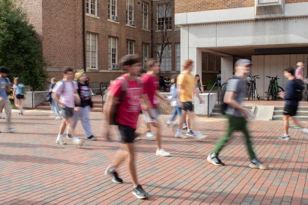 <p>A blur of students traverse the UNC grounds on Monday, March 6, 2022.</p>