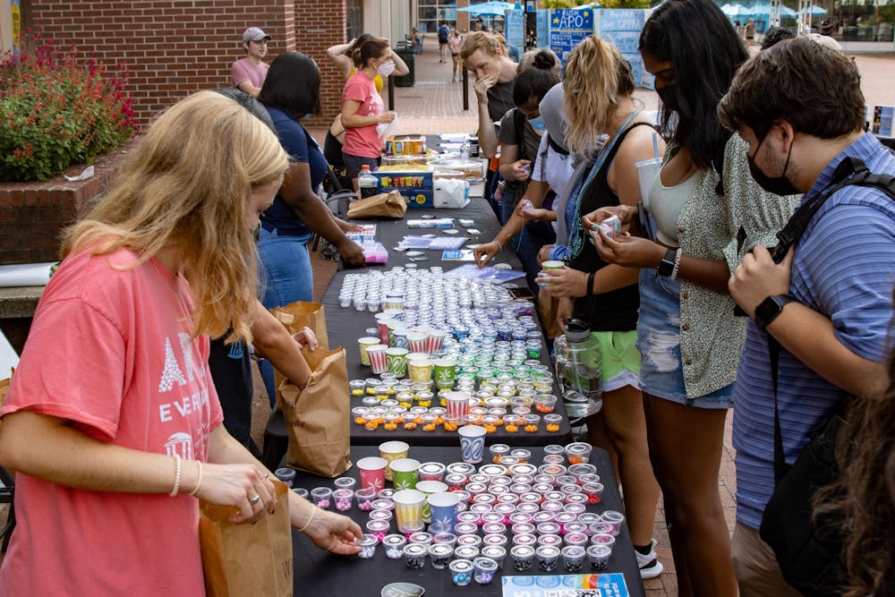 Students select materials to make bracelets during Arts Everywhere's "Fall Arts Pop-Up" in front of Davis Library on Sept. 16, 2021.