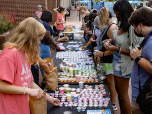 Students select materials to make bracelets during Arts Everywhere's "Fall Arts Pop-Up" in front of Davis Library on Sept. 16, 2021.