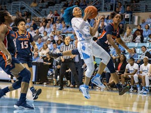 UNC redshirt senior guard Madinah Muhammed (3) aims for the hoop with University of Virginia first-year guard Shemera Williams (10) on defense. The Tar Heels beat the Cavaliers 78-68 in Carmichael Arena on Jan. 30, 2020.