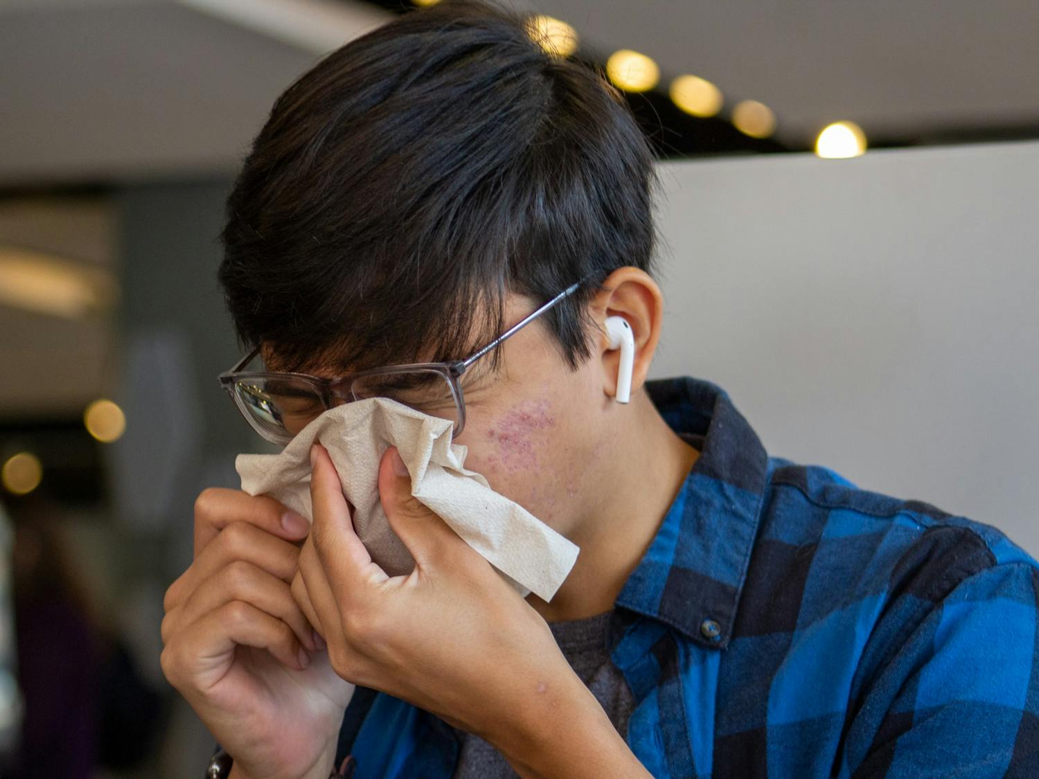 Student blows nose inside the student union at Alpine Bagel on Oct. 10, 2022.