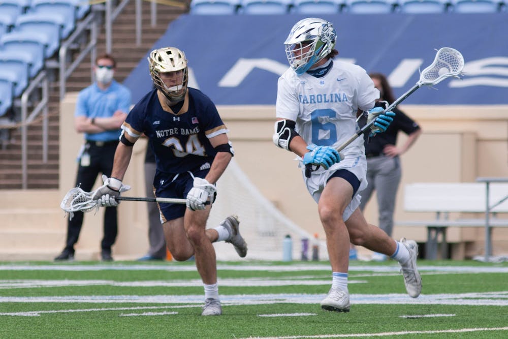 UNC first-year midfielder Cole Herbert (6) cradles the ball during the game against Notre Dame on April 25, 2021 at Kenan Stadium. The Tar Heels' defeated the Fighting Irish 12-10.