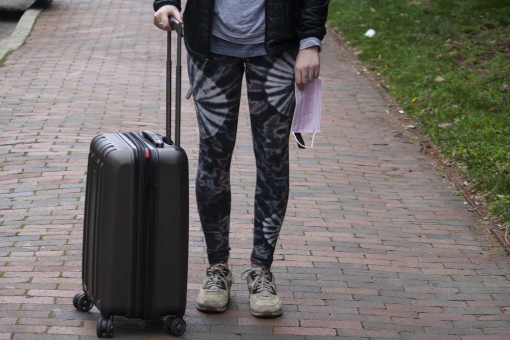 <p>DTH Photo Illustration. A UNC student holds a suitcase and a surgical mask on campus on Tuesday, March 3, 2020. Students are unsure how the coronavirus will affect their plans to study abroad.</p>
