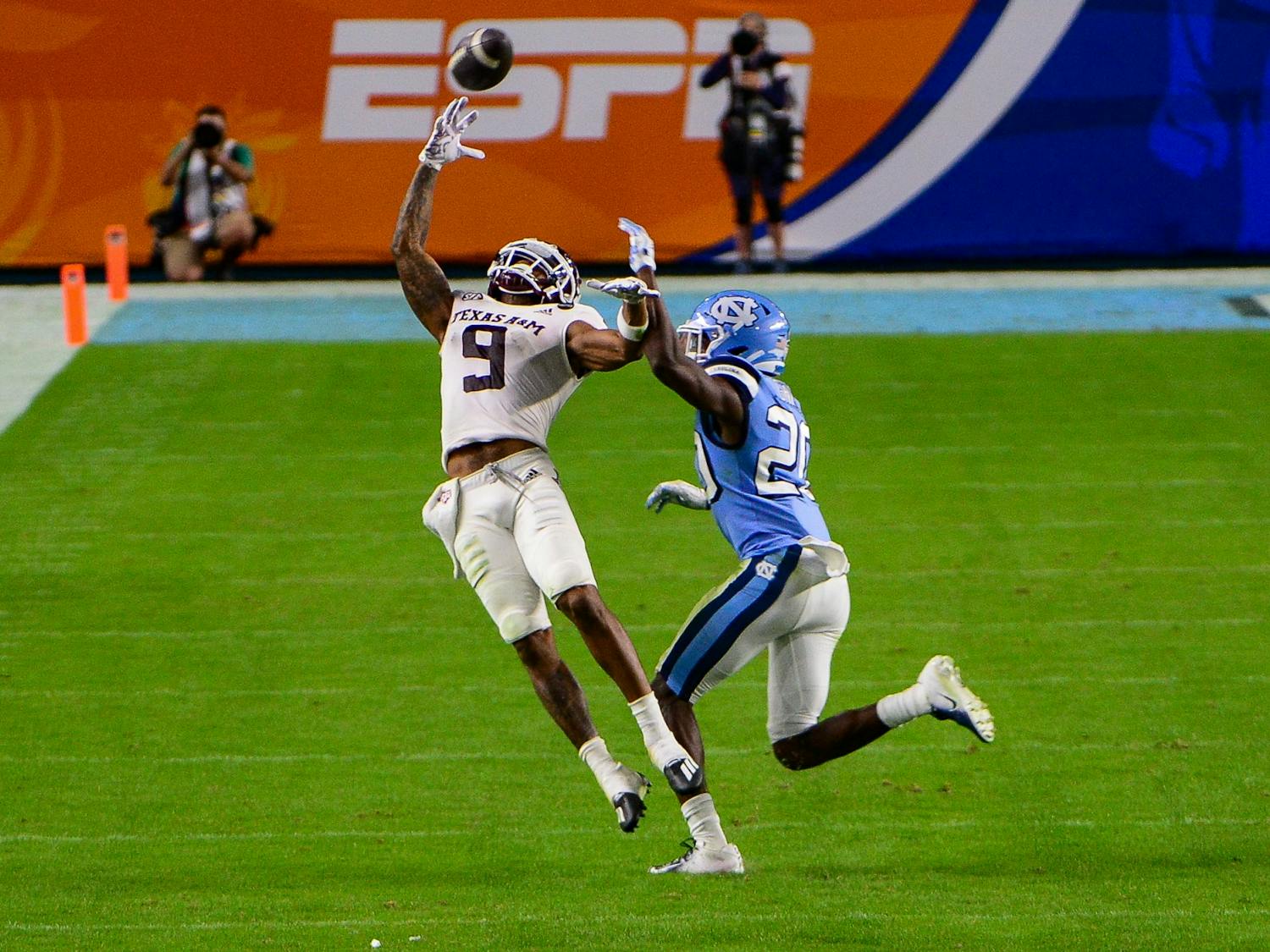 Texas A&M junior wide receiver Hezekiah Jones (9) attempts to catch the ball around UNC's first year defensive back Tony Grimes (20) during the Capital One Orange Bowl in Hard Rock Stadium on Saturday, Jan. 2, 2021. Texas A&M beat UNC 41-27.