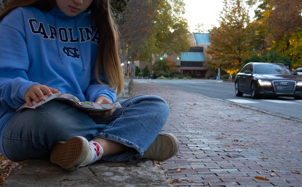 DTH Photo Illustration. A UNC student reads a Bible on campus. 