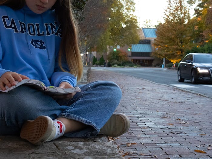 DTH Photo Illustration. A UNC student reads a Bible on campus. 