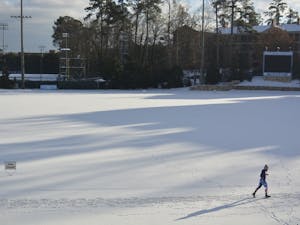 A runner circles the snow covered track around Fetzer Field in Chapel Hill, NC, on Jan. 7, 2017.