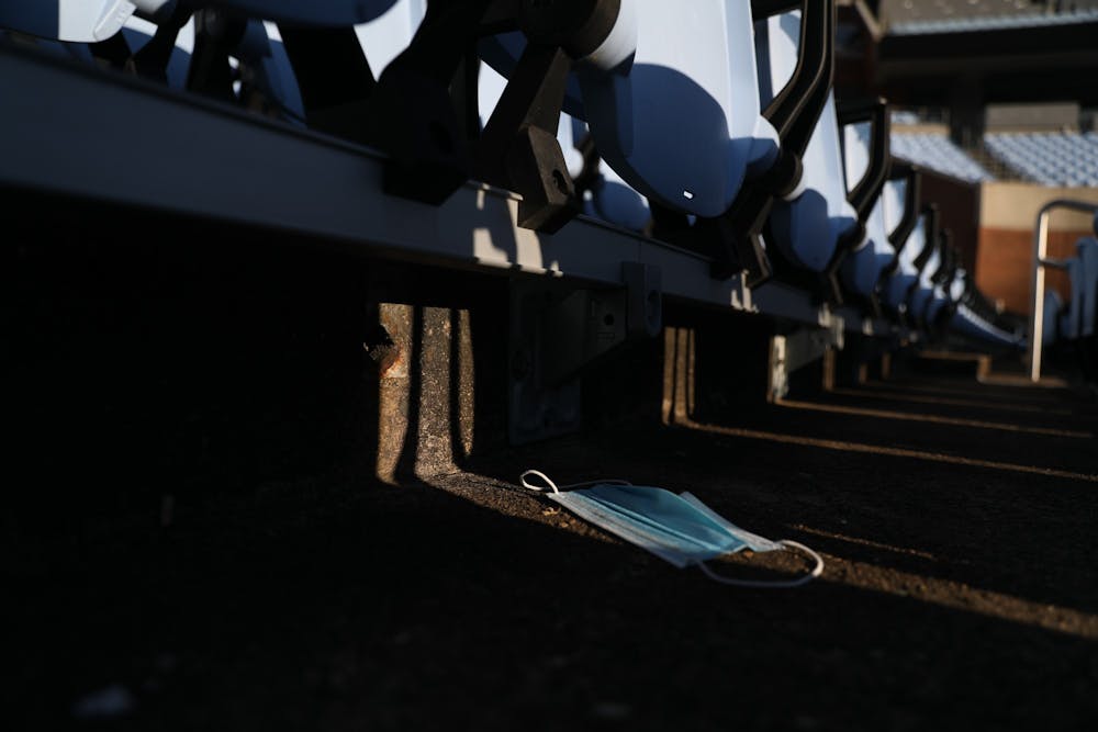<p>A discarded mask lies under empty chairs in Kenan Stadium on Thursday, Jan. 6, 2022.</p>