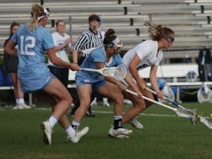UNC midfielders, Ally Mastroianni (12) and Gianna Bowe (21), attempt to regain possession of the ball from Duke midfielder, Catriona Barry (19). No.3 UNC defeated No.13 Duke 19-5 on Saturday, April 20, 2019 at Koskinen Stadium at Duke University. UNC will enter the upcoming ACC Tournament as a No.2 seed.