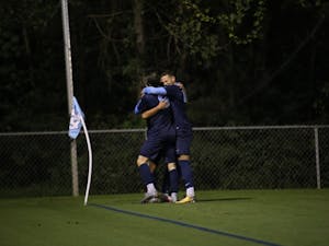Jack Skahan and Zach Wright embrace Lucas del Rosario after he scores the game winning goal to beat Old Dominion University in double overtime.