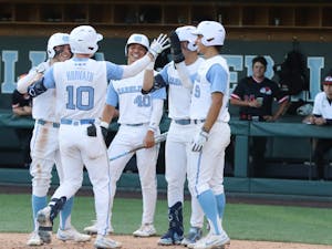 UNC sophomore infielder Mac Horvath (10) celebrates with teammates at home plate after hitting a grand slam during a home game at Boshamer Stadium against Gardner-Webb on Tuesday, May 10, 2022.