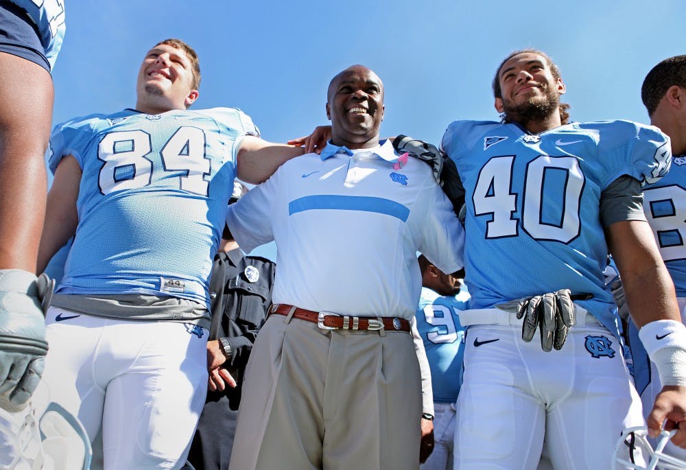 UNC interim head coach Everett Withers celebrates with team after UNC's 14-7 win over Louisville. 