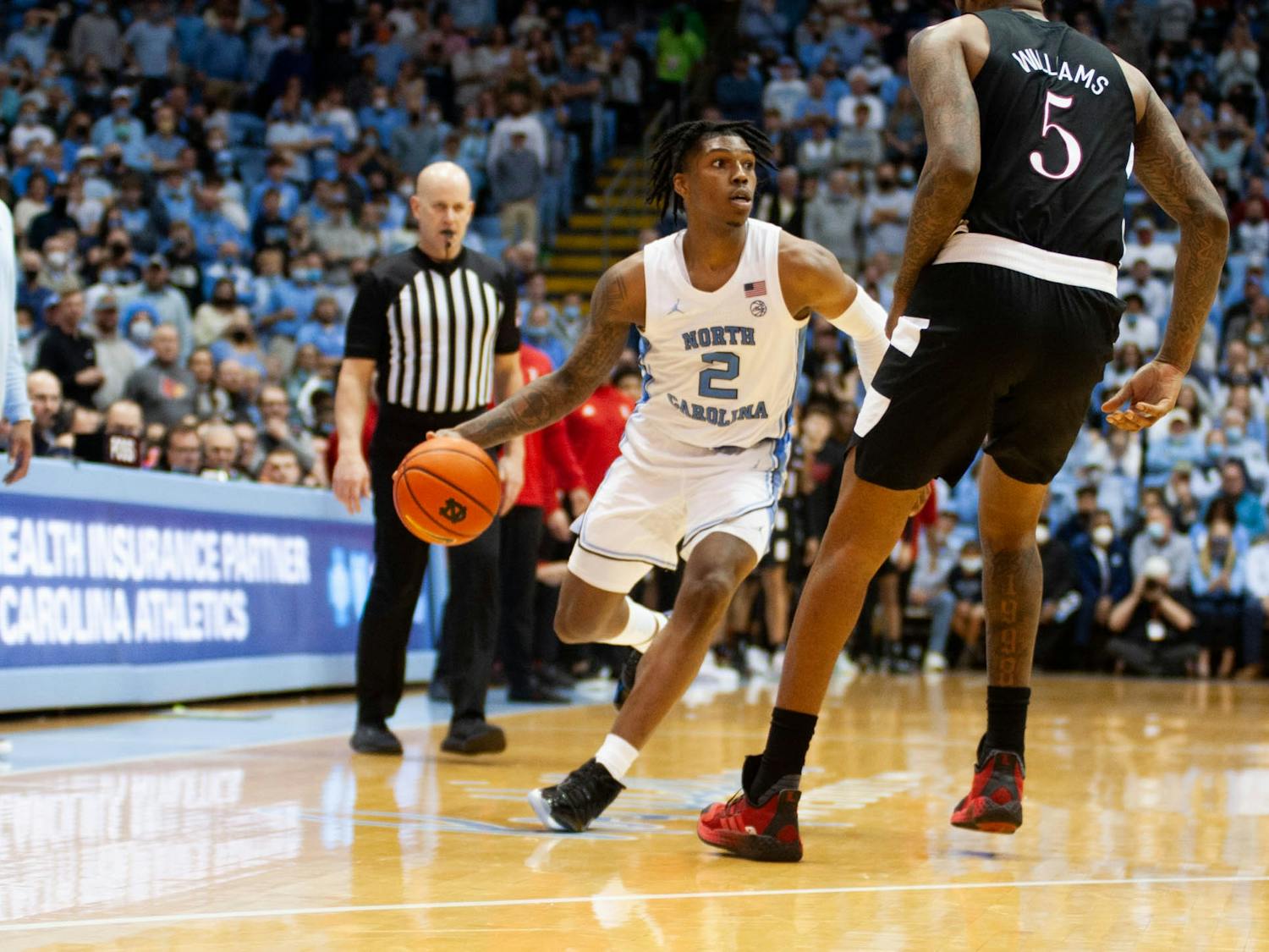 UNC sophomore guard Caleb Love (2) evades a defender during a home men's basketball game against Louisville on Monday, Feb. 21, 2022. UNC won 70-63.