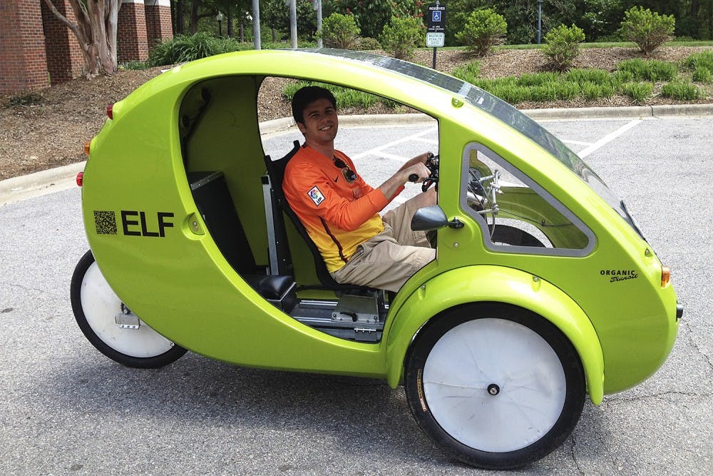 <p>Patrick White, a senior business major, tests out an alternative form of transportation, a one-person-electrical bicycle called an ELF, in the parking lot of Kenan-Flagler on Monday afternoon.</p>