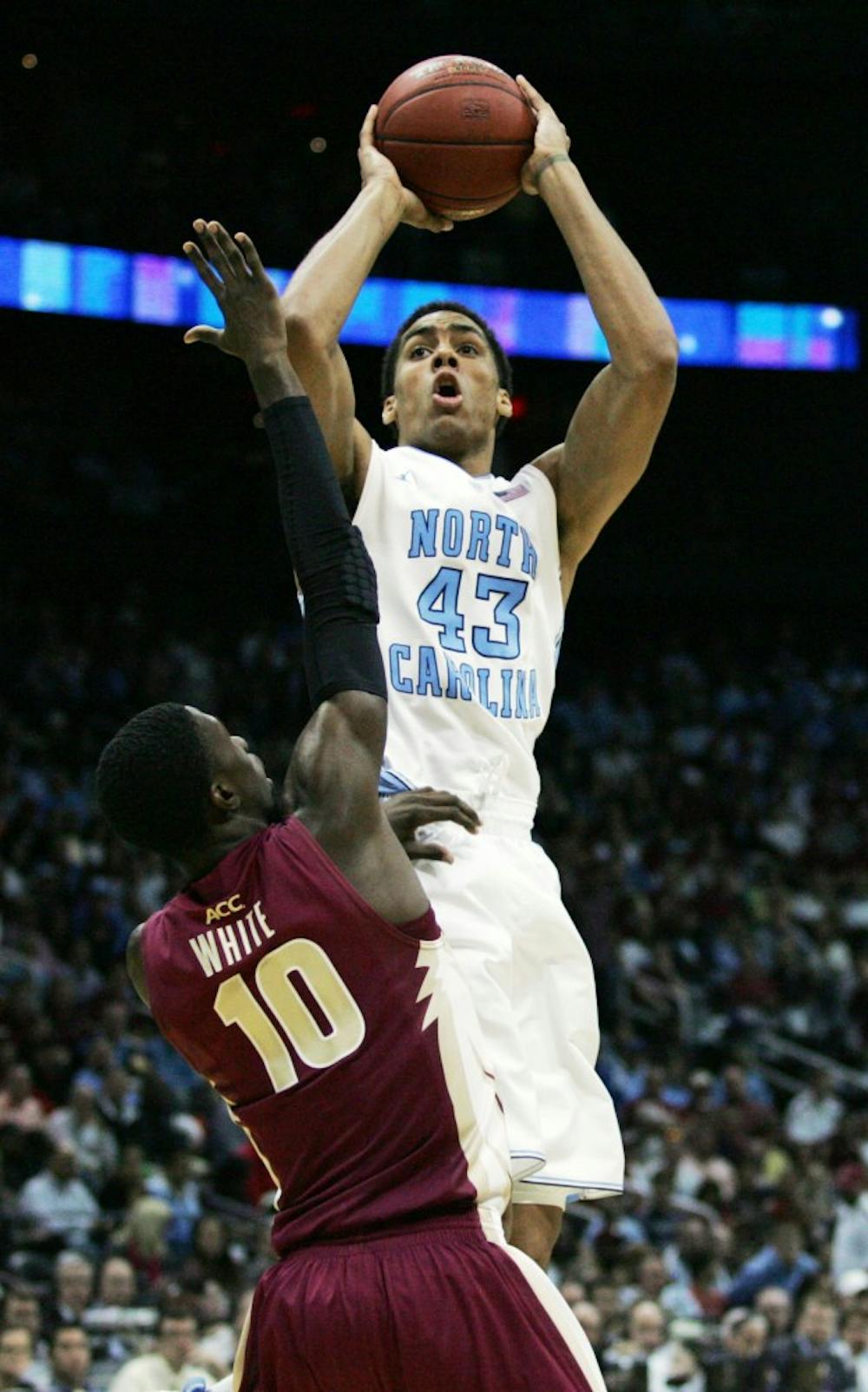 James McAdoo sails over Okaro White while taking a shot. 