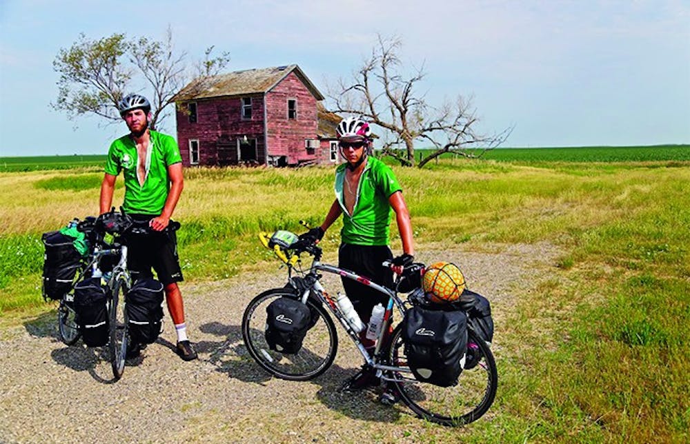 	Aidan Kelley (left) and DJ Recny, take a break outside an abandoned house in South Dakota. They bike cross-country to raise money for charity.