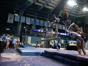 A composite image shows freshman Lali Dekanoidze dismounting from the beam during UNC's meet against West Virginia at Carmichael Arena on Feb. 24, 2022. 