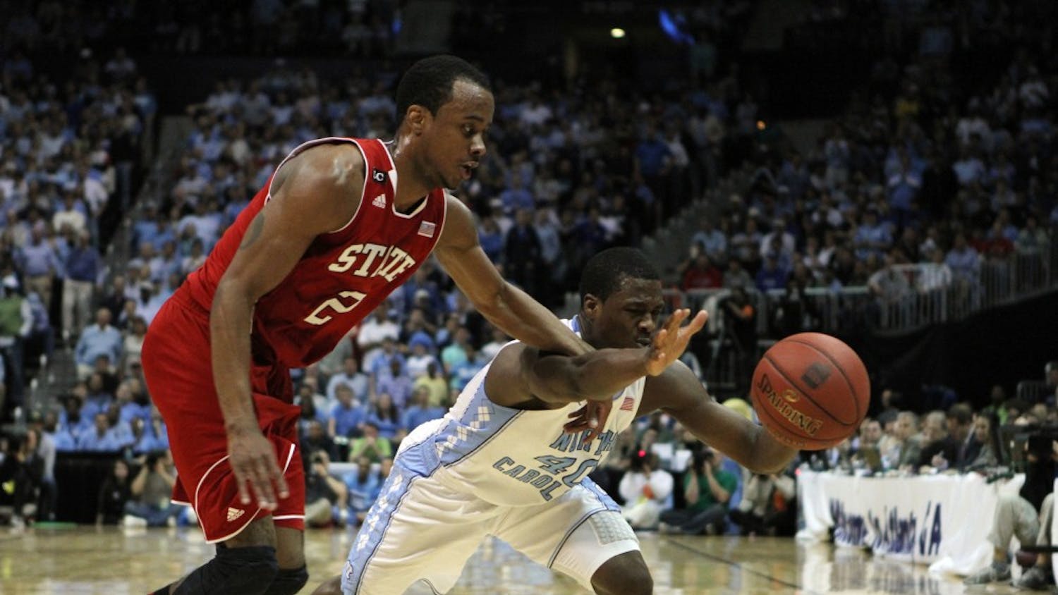 Lorenzo Brown and Harrison Barnes dive for a loose ball during the first half of play. The Tar Heel forward scored 16 points during the game. 