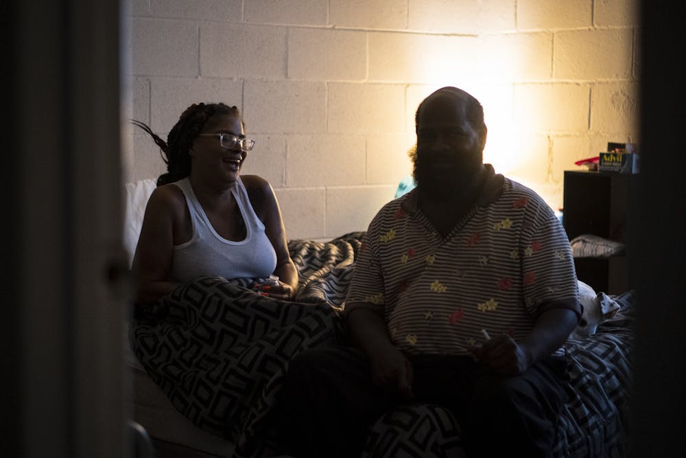 Layota Smith and Demonte Folks sit on their bed on July 24th. Smith and Folks are residents of University Gardens Condos in Chapel Hill, N.C.