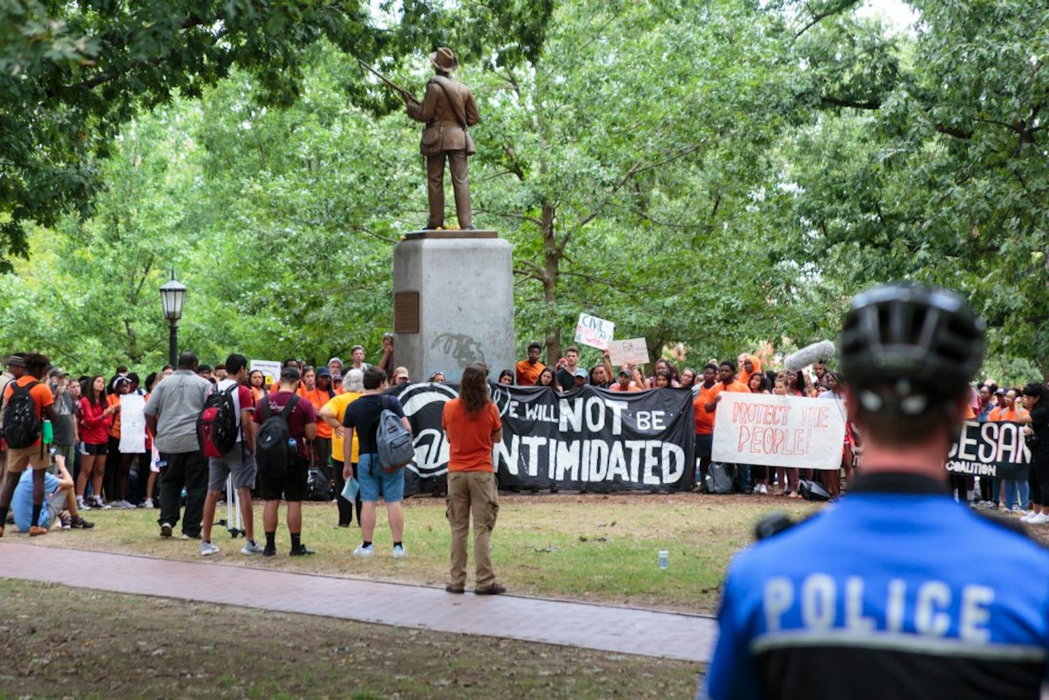 Police watch over a group of protestors near the Silent Sam statue during a demonstration on Thursday afternoon.&nbsp;