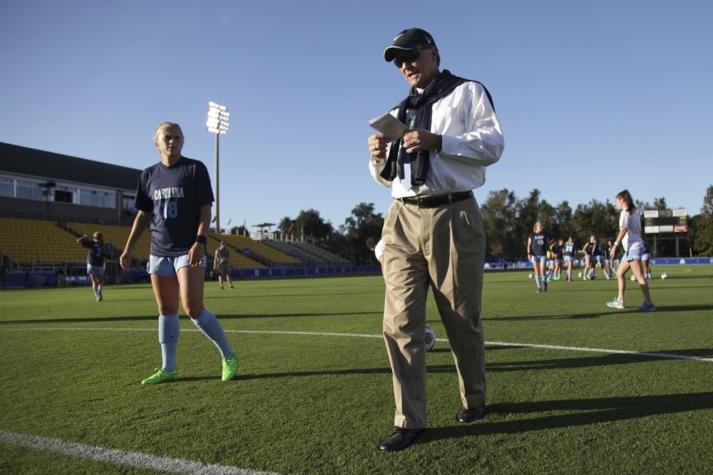 <p>UNC women's soccer head coach Anson Dorrance looks over his notes as he walks around at practice.</p>
