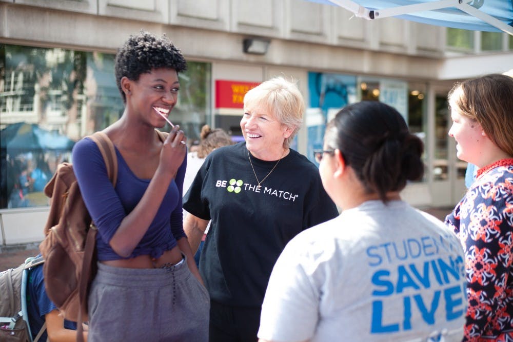 Sylvia Hatchell, UNC women's basketball coach, helps first-year Ajani Anderson swabs her cheek at the Be The Match event on Oct. 5 in the Pit.