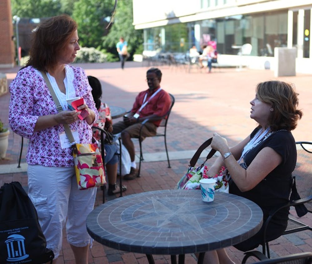 Laura Kilmartin (left) and Helen Shearer drink coffee in front of the Student Union. DTH/Stephen Mitchell