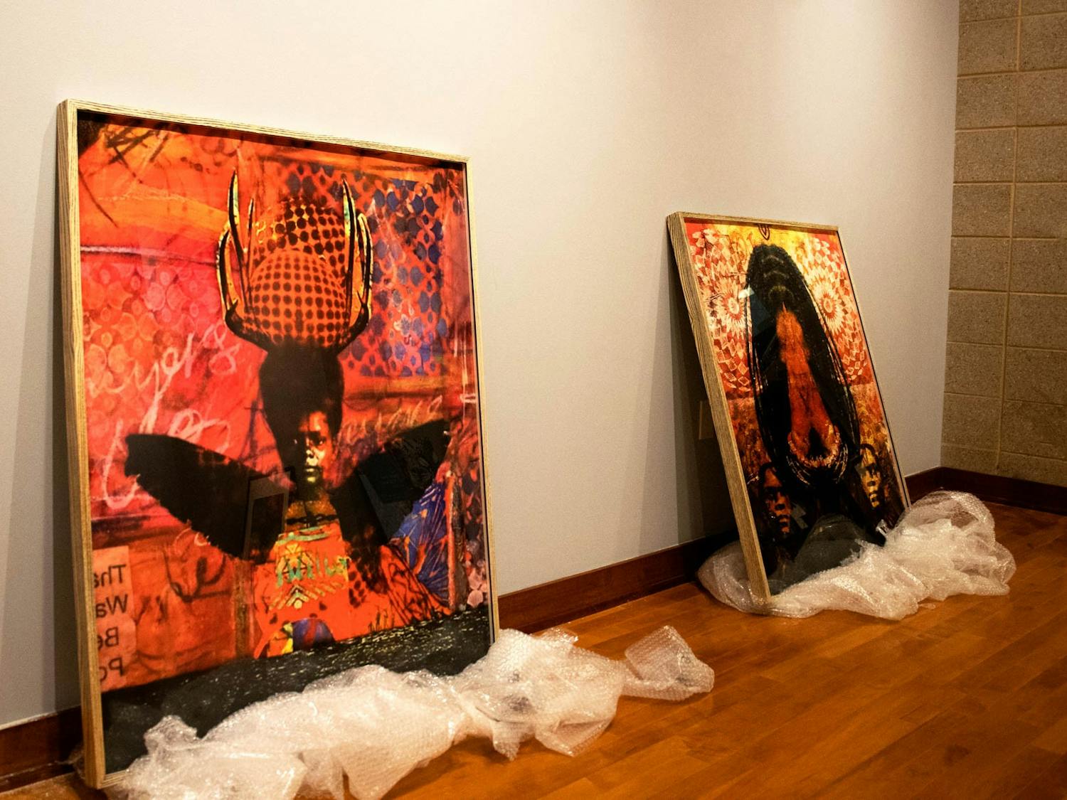 Prints in the process of being installed in the Stone Center's Brown gallery as a part of Anike Robinson's Gris Gris Gurlz exhibition, photographed on Monday, Sept. 19, 2022.
