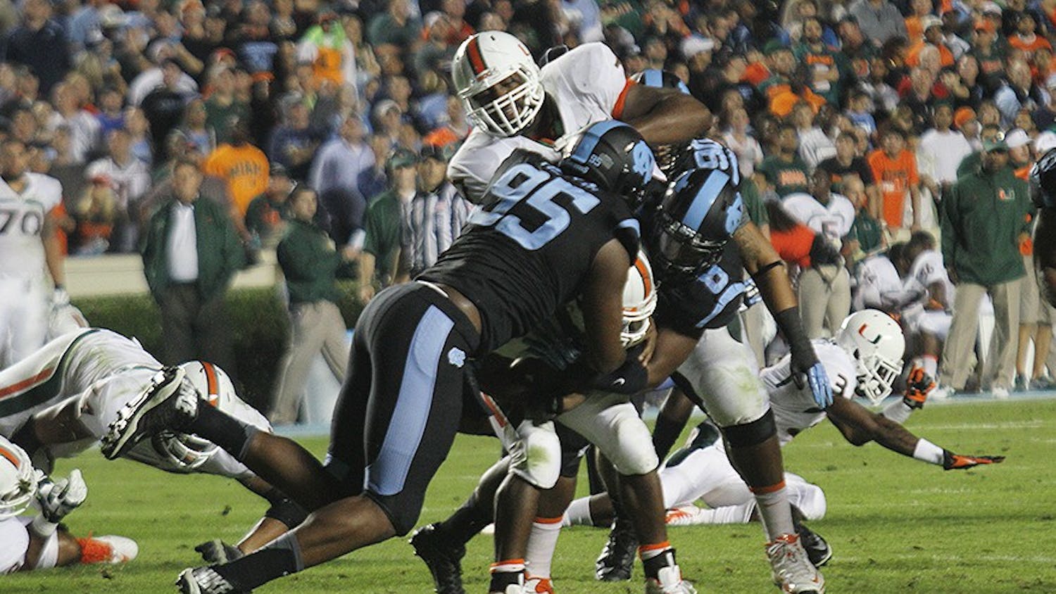 	Kareem Martin (95), a senior defensive end, assists a teammate in tackling a player during the game against Miami on Oct. 17. Martin won the ACC’s defensive lineman of the week for his performance.