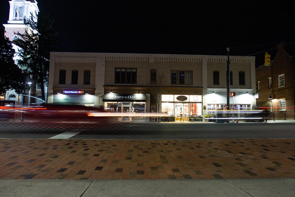 <p>Cars drive on Franklin Street at night on Sunday, Feb. 16, 2020 before the COVID-19 pandemic. Now, the pictured businesses and many others on Franklin Street have either ceased operations entirely or have adapted their operations for the current crisis.</p>