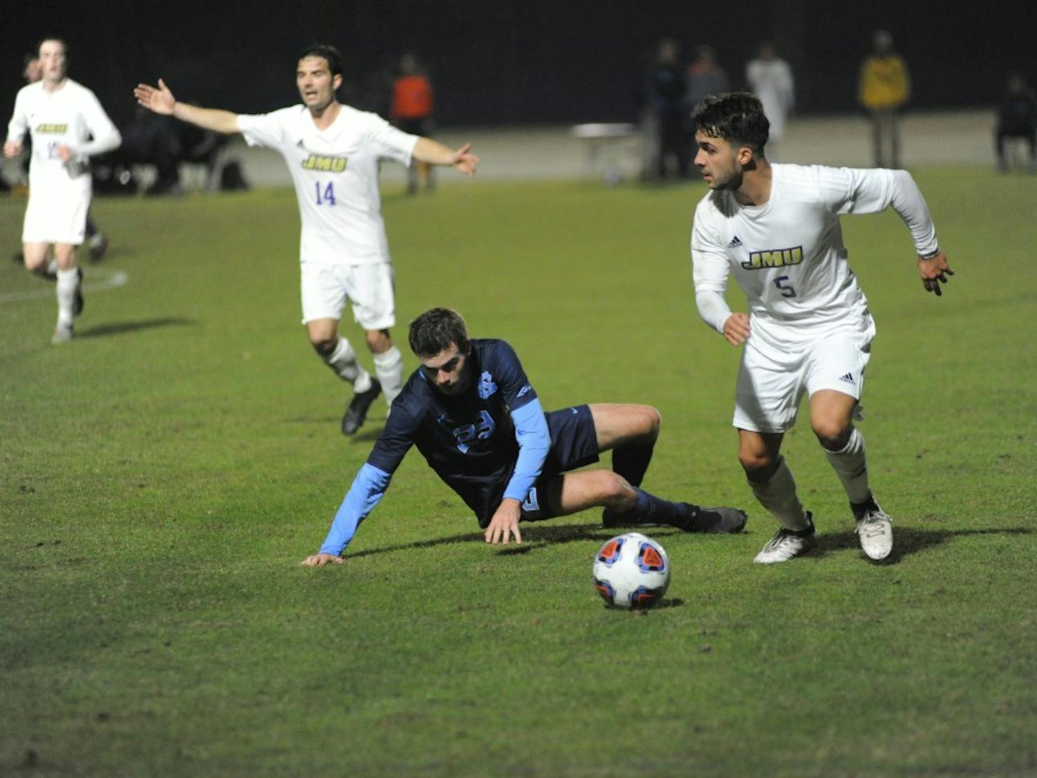 James Madison midfielder Niclas Mohr (5) dribbles past midfielder Jeremy Kelly (29) during Sunday's NCAA tournament game vs. James Madison. The Tar Heels lost 2-1.
