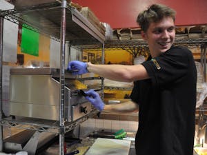 UNC first-year student and Cosmic Cantina employee Samuel Finlay makes a burrito on Thursday, Mar. 21. Starting Apr. 2, Cosmic will increase its prices by 9% in order to support rising food costs and employee wages. 