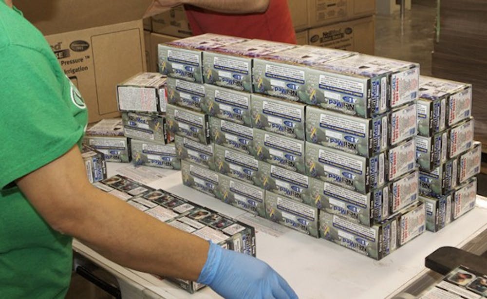 	Employees of NeilMed Pharmaceuticals Inc. repackage nasal spray and gel kits customized to send to troops overseas. Photo courtesy of NeilMed Pharmaceuticals Inc.