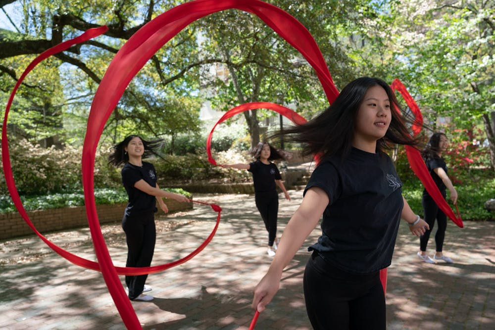 Seanna Chen, Katherine Zhang, Grace Chow, and Carina Lin pose for a portrait in the Coker Arboretum on Friday, April 15, 2022. Chen, Zhang, Chow, and Lin are members of UNC's Flying Silk, a Chinese dance group that focuses on ribbon and fan dance.
