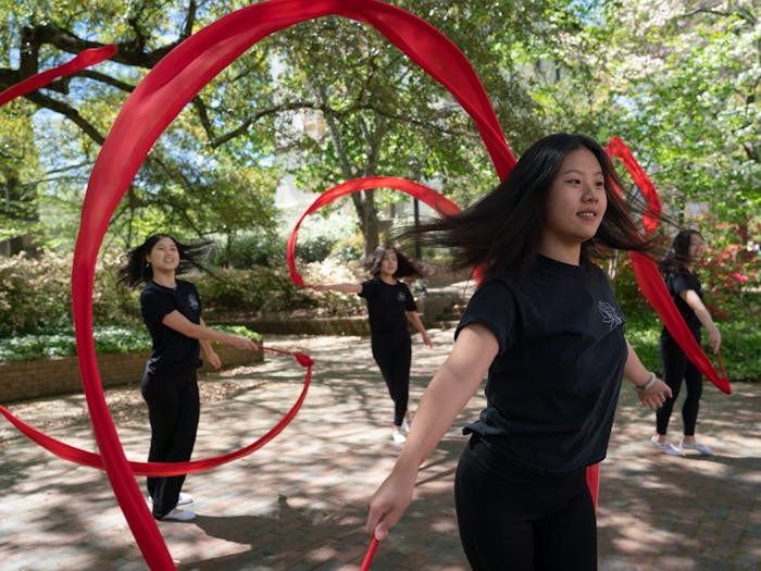 Seanna Chen, Katherine Zhang, Grace Chow, and Carina Lin pose for a portrait in the Coker Arboretum on Friday, April 15, 2022. Chen, Zhang, Chow, and Lin are members of UNC's Flying Silk, a Chinese dance group that focuses on ribbon and fan dance.