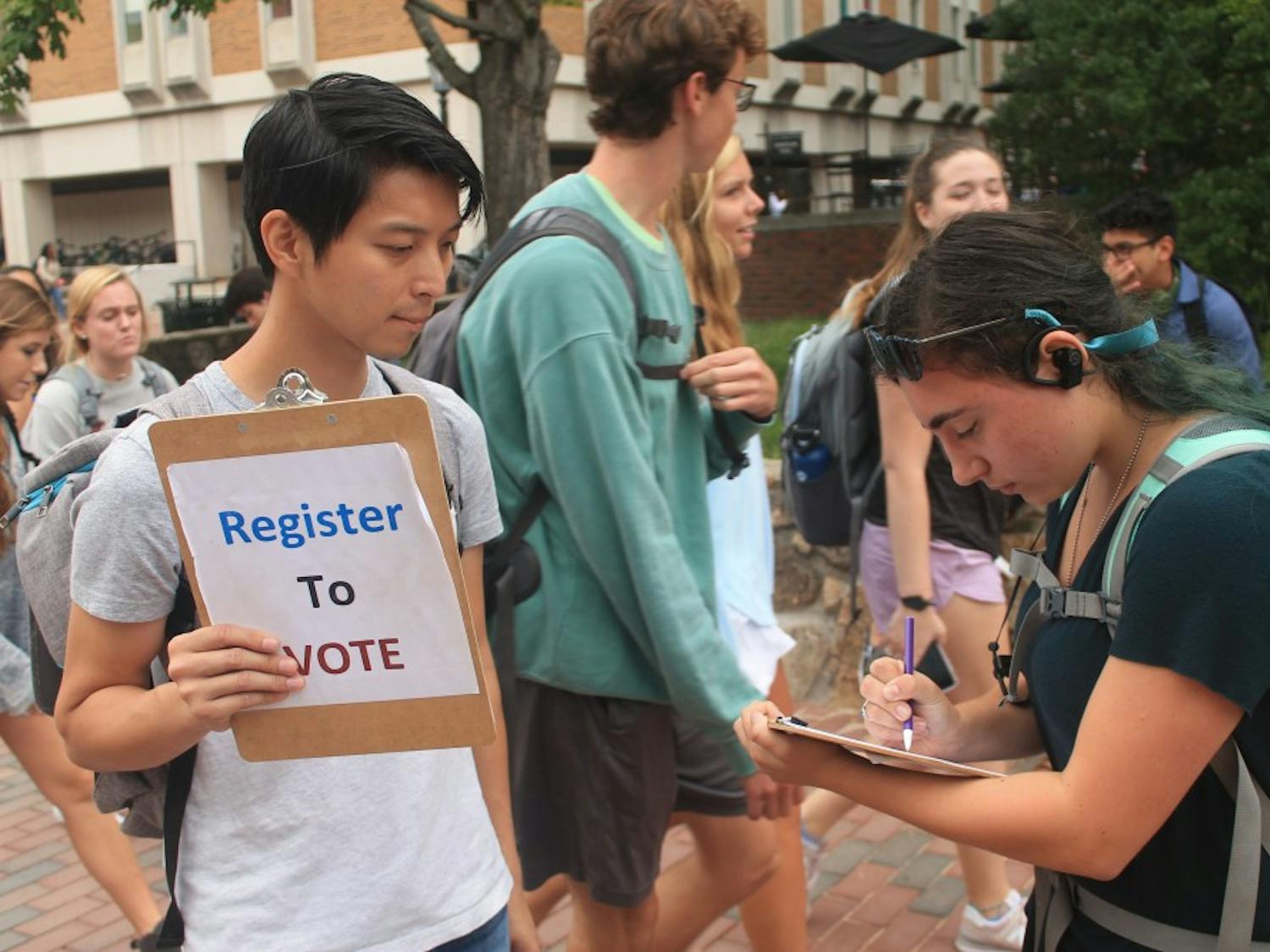 Ricky Leung (left) asks UNC student Samantha Mndello (right) to register to vote for the 2018 election in the Pit on Monday, Sept. 24. 