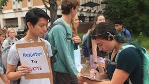 Ricky Leung (left) asks UNC student Samantha Mndello (right) to register to vote for the 2018 election in the Pit on Monday, Sept. 24. 