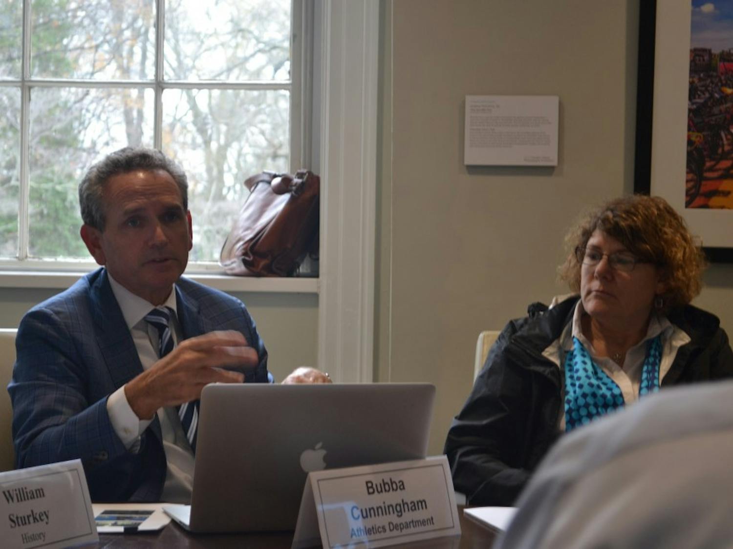 UNC Athletic Director Bubba Cunningham and Jaye Cable discuss the minutes during the Faculty Executive Committee Meeting on Tuesday, Sept. 10, 2019.&nbsp;
