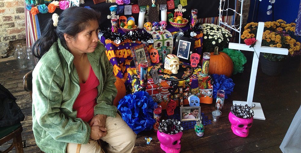 	Poultry farmworker Miranda Albo sits by an altar that honors farmworkers who have died on the job. North Carolina is home to 28,000 poultry workers just like Albo — a group whose days often start at 5 a.m. as they begin to make their way to thousands of farms across the state. Photo courtesy of Ever Castro.