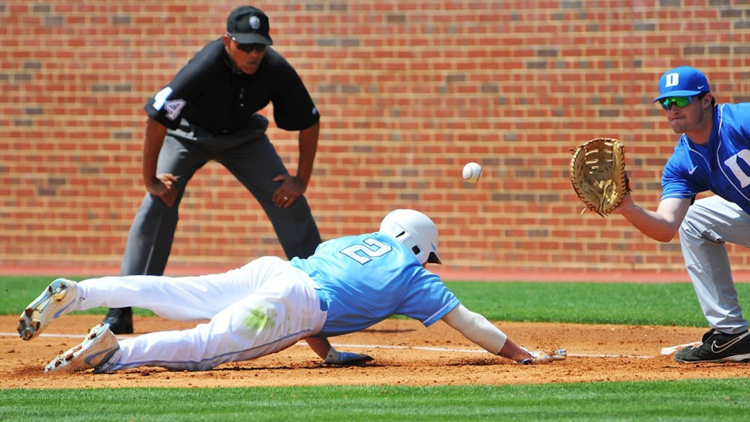 	Chaz Frank dives back toward the bag during Sunday’s game.  The senior outfielder was one-for-five on Sunday but totaled four hits on the weekend. 