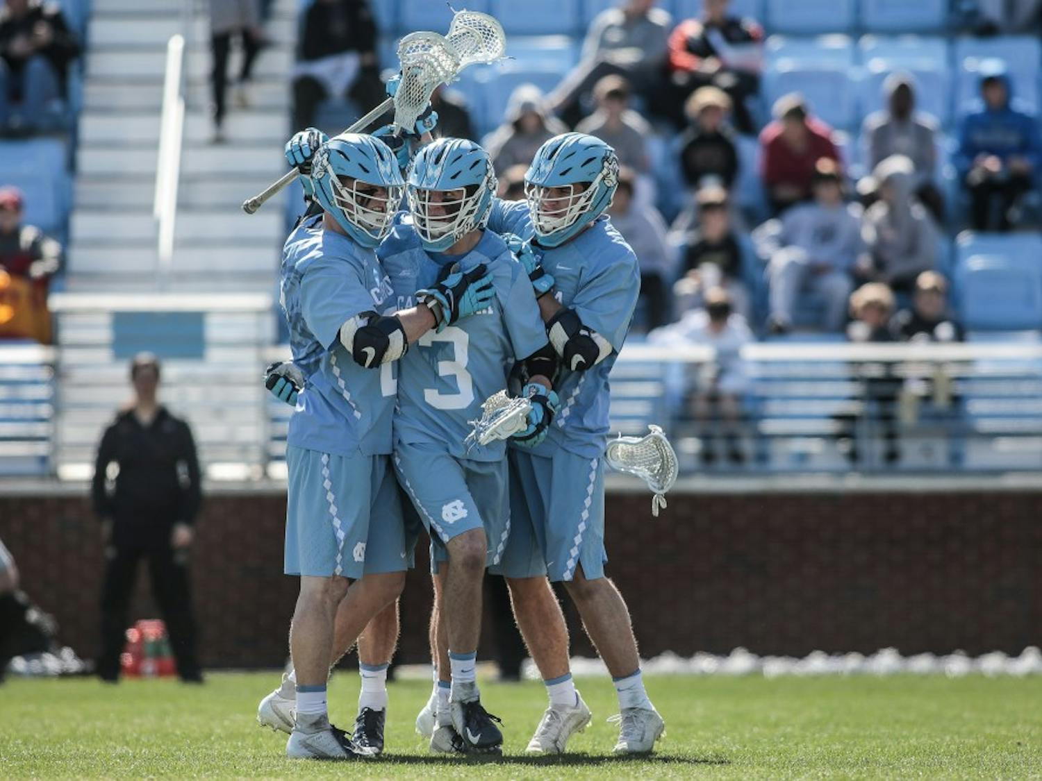 UNC junior midfielder William Perry (3) celebrates after scoring a goal with teammates Justin Anderson (21) and Andy Matthews (12) during UNC's 12-10 home loss against the University of Denver on Saturday, March 3, 2019 at the UNC Soccer and Lacrosse Stadium in Chapel Hill, N.C. This was the UNC Men's Lacrosse team's inaugural game at the UNC Soccer and Lacrosse Stadium.