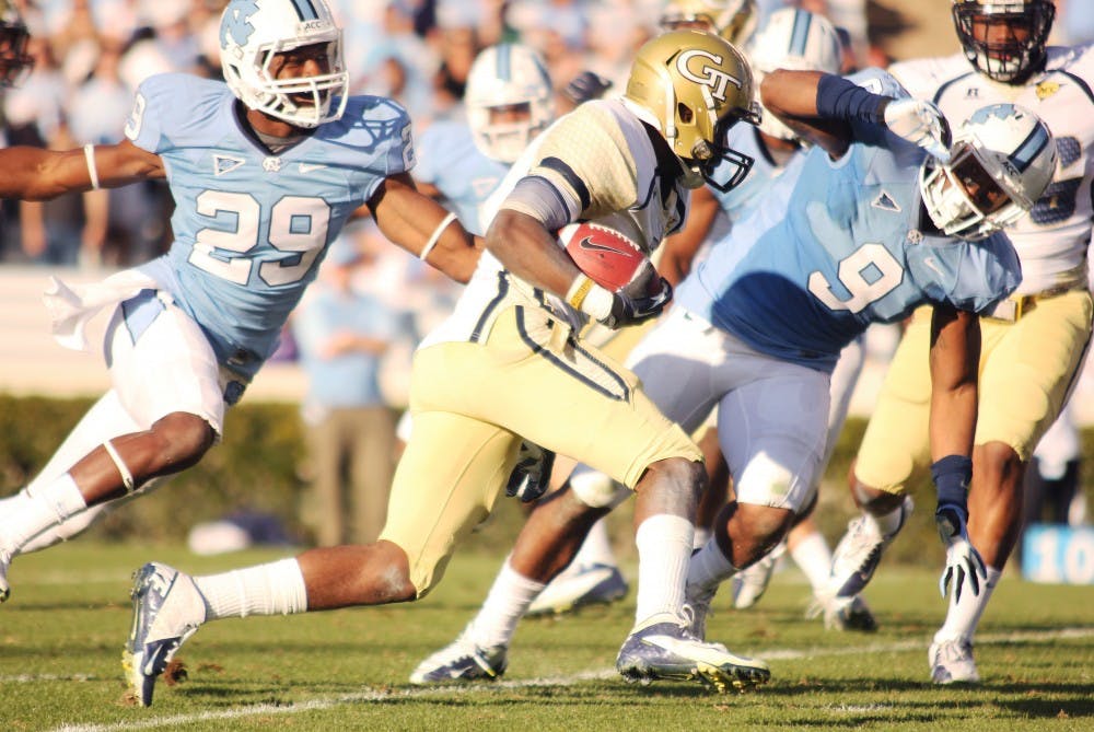 	Damien Washington (29) and Travis Hughes (9) try to tackle a Georgia Tech player.
