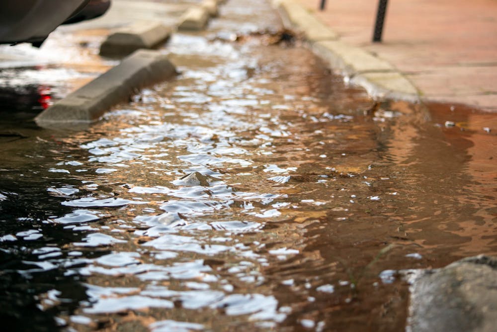 <p>Water flows onto the sidewalk near UNC's Carrington Hall on Thursday, Feb. 23, 2023.</p>